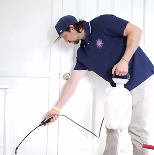 Boise Bug Bombers technician Jordan Hollowell applying an interior pest treatment in Boise, Idaho.