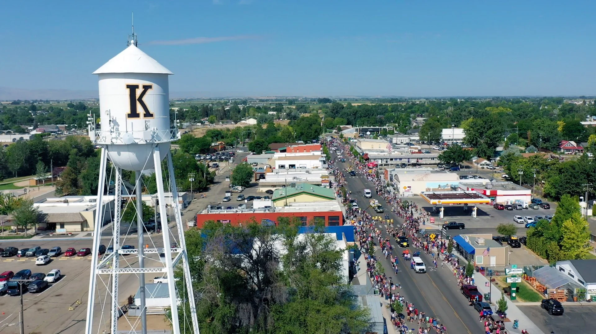 Aerial photograph of downtown Kuna, Idaho — main street with the iconic "K" water tower visible, the small town Boise Bug Bombers serves